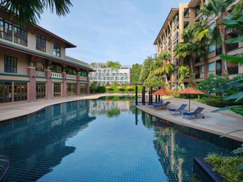 a swimming pool in the middle of a building at Novotel Phuket Vintage Park Resort in Patong Beach