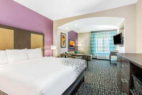 a hotel room with a bed and a flat screen tv at La Quinta by Wyndham Hillsboro in Hillsboro