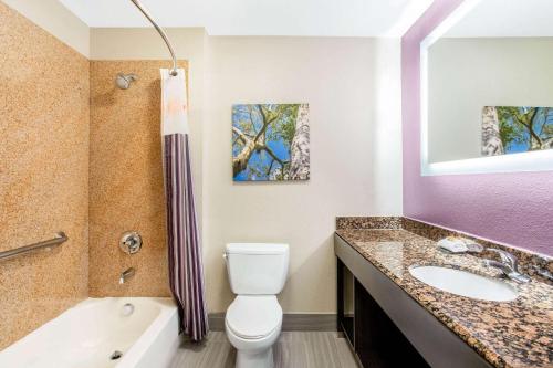 a bathroom with a toilet and a sink and a tub at La Quinta by Wyndham Hillsboro in Hillsboro