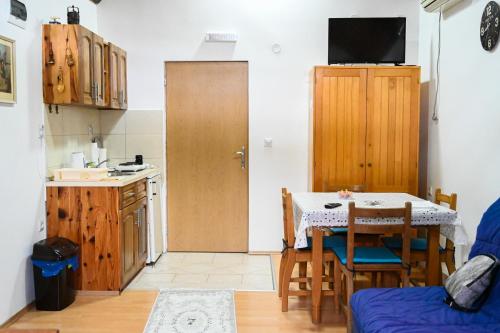 Tri bagrema KM في موكرا غورا: مطبخ مع طاولة ومطبخ صغير مع طاولة وكراسي