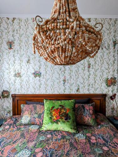 a chandelier hanging over a bed in a bedroom at Jamaica Mid-Century in Seaton