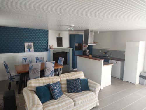 uma sala de estar com um sofá, uma mesa e uma cozinha em Les gîtes de Denise, proche Saint-Malo au calme em Bonnemain
