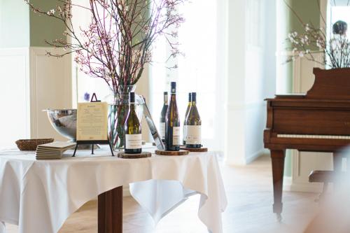 a table with bottles of wine and a piano at Stammershalle Badehotel in Bådsted