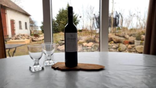 una botella de vino sentada en una mesa con dos copas en Salarpsgården en Hammenhög