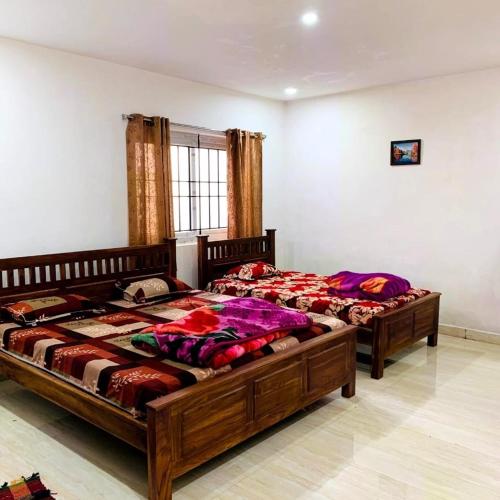 two twin beds in a room with at Kalyani Homestay in Kodaikānāl