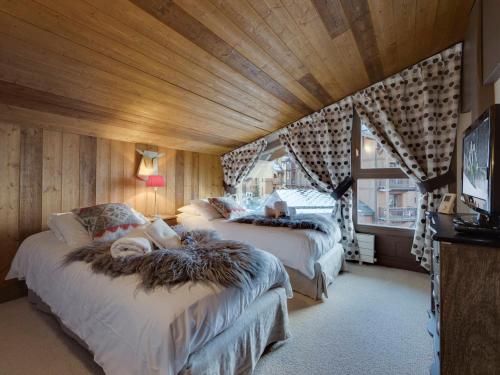 a bedroom with two beds and a tv in it at Appartement Tignes, 5 pièces, 8 personnes - FR-1-641-15 in Tignes