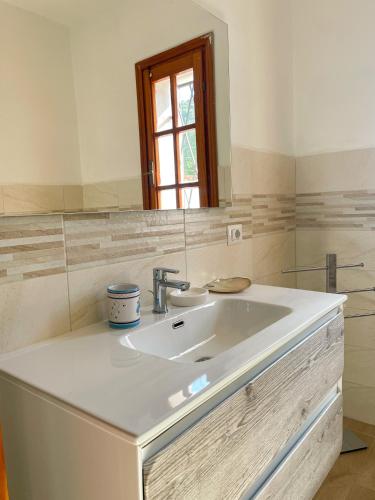 a bathroom with a white sink and a window at Tipica Villa Gallurese in Costa Smeralda in Cugnana