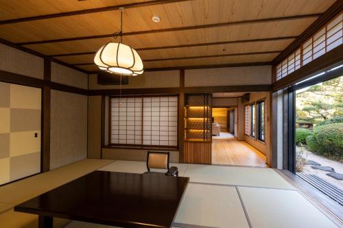 a dining room with a table and a large window at Hagi No Yado Tomoe in Hagi
