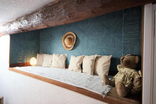 a bed with white pillows and a teddy bear at Appartement le Mehari in Cassis