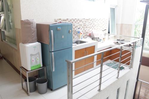 a kitchen with a blue refrigerator and a sink at G10 Guest House Near Asia Afrika Bandung in Bandung