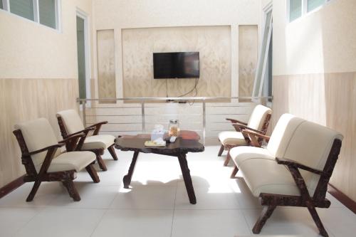 een kamer met stoelen, een tafel en een tv bij G10 Guest House Near Asia Afrika Bandung in Bandung