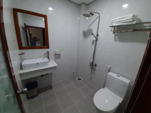 ein Badezimmer mit einem WC, einem Waschbecken und einem Spiegel in der Unterkunft Cát tường 2 hotel in Ho-Chi-Minh-Stadt