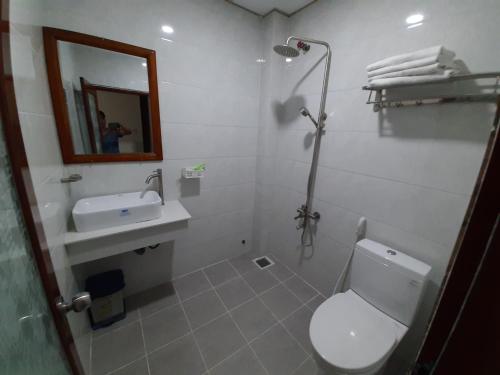a bathroom with a toilet and a sink and a mirror at Cát tường 2 hotel in Ho Chi Minh City