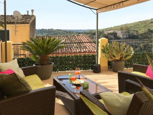 a patio with a table and chairs on a balcony at Casa Alva in Ragusa