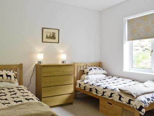 um quarto com 2 camas e uma janela em Corrie Massan em Benmore