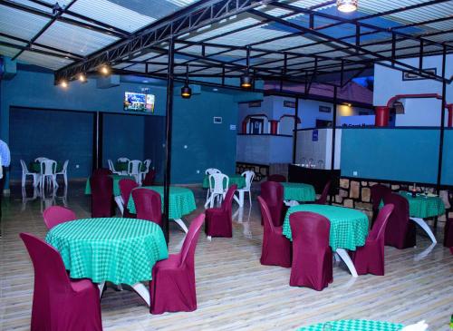 a dining room with tables and chairs in a room at SKYLIGHT MOTEL Airport Road in Kigali