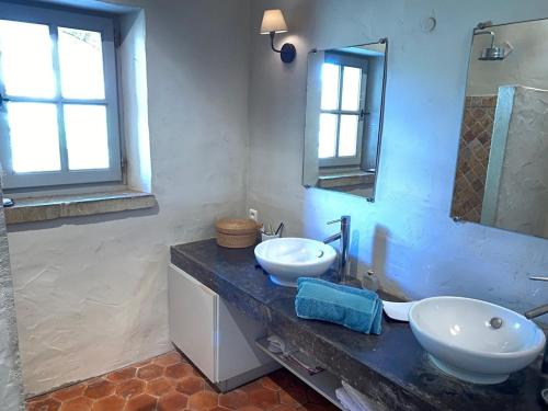 a bathroom with two sinks and a mirror at In Gordes, facing the entire Luberon Park a beautiful 5 bedrooms house in Gordes