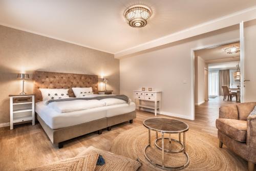 a bedroom with a bed and a couch and a table at Aparthotel Friesenhof in Wenningstedt
