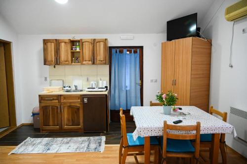 a kitchen with a table and chairs and a table and a kitchen with a sink at Tri bagrema KM in Mokra Gora