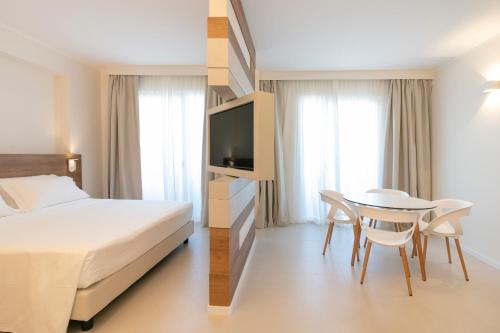 ein Hotelzimmer mit einem Bett, einem Tisch und Stühlen in der Unterkunft Hotel Mistral in Termoli
