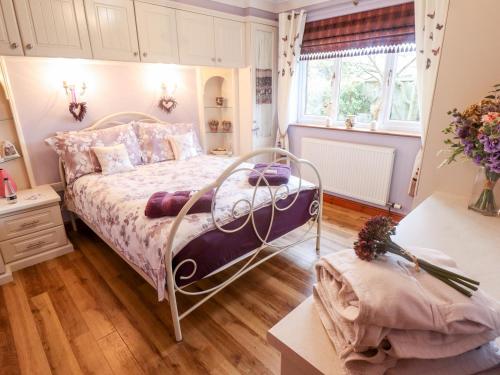 1 dormitorio con cama, mesa y ventana en Tawny Owl Cottage, en Louth