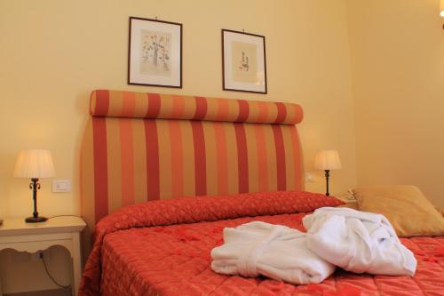 a bedroom with a bed with a striped headboard at Il Parco Sul Mare Resort & SPA in Tortoreto Lido