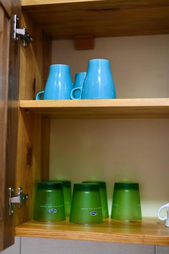a row of green bowls on a shelf at Tri bagrema KM in Mokra Gora