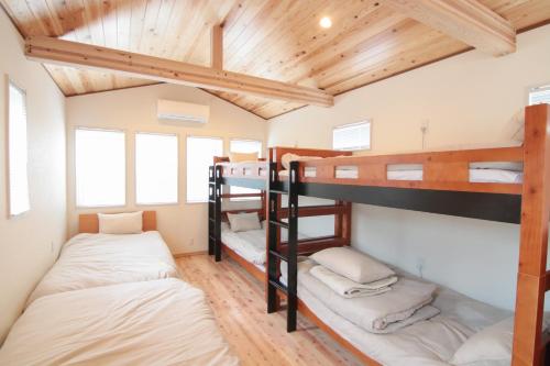 2 łóżka piętrowe w pokoju z drewnianym sufitem w obiekcie BATH B / Vacation STAY 54888 w mieście Beppu