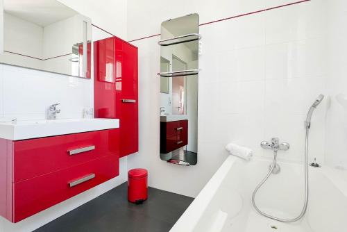 uma casa de banho com um armário vermelho e um lavatório em Penthouse vue incroyable lac et montagnes em Annecy