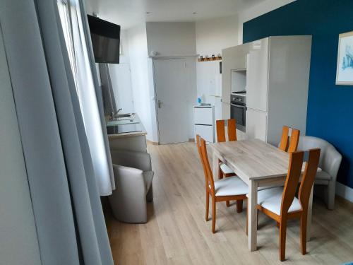 une cuisine et une salle à manger avec une table et des chaises dans l'établissement Appartement accueillant à Saint-Quay-Portrieux 35 m² ensoleillé, à Saint-Quay-Portrieux