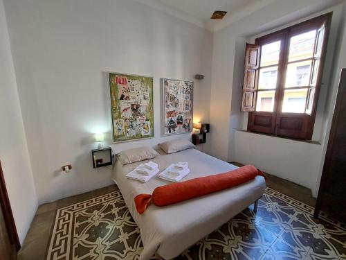 Un dormitorio con una cama blanca con almohadas rojas. en Il Vecchio Piano, en Castrovillari