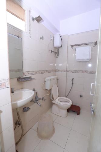 HOTEL RUNWAY INN في أحمد آباد: حمام مع مرحاض ومغسلة