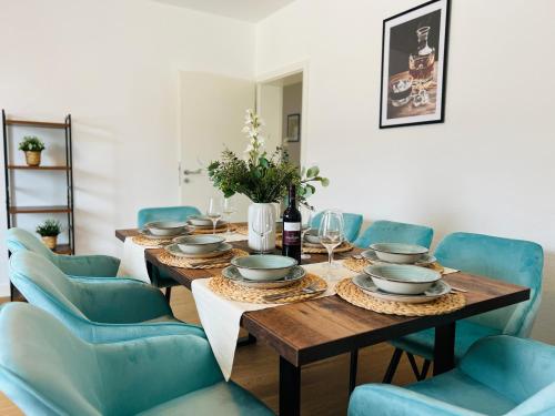 comedor con mesa de madera y sillas azules en BIG-6-Guests-Kingsize-Netflix-Badewanne-Hauptbahnhof-Zentral, en Coblenza