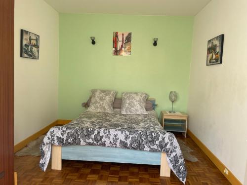a bedroom with a bed and two pictures on the wall at CALME in Drancy