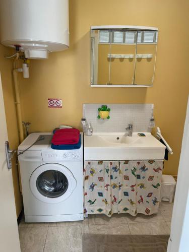 uma casa de banho com uma máquina de lavar roupa e um lavatório em CALME em Drancy