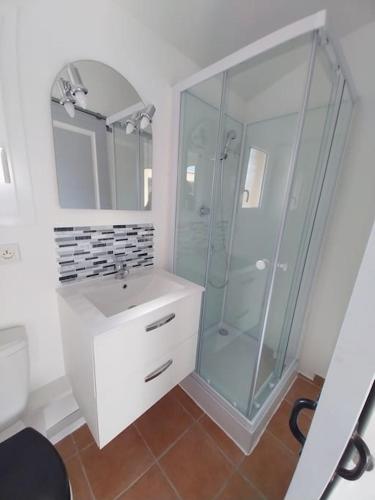 une salle de bain avec une douche en verre et un lavabo dans l'établissement centre historique et proche mer, à Sigean