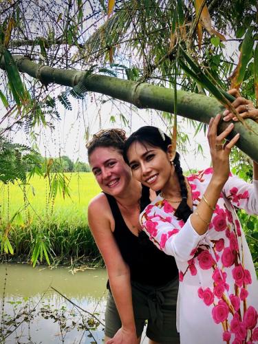 a man and a woman standing under a tree at Song Ngư Riverside Homestay in Can Tho