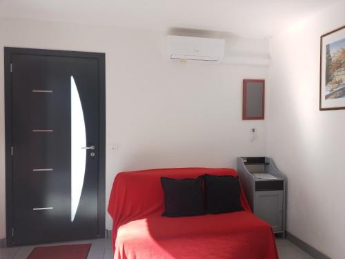 マルモールにあるAppartement Le Romarinの赤いベッドと黒いドアが備わるベッドルーム1室が備わります。