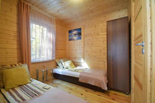 a small room with a bed and a window at Domek Letniskowy Diana in Pogorzelica
