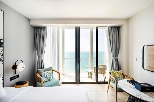 una camera da letto con un letto e vista sull'oceano di Anya Premier Hotel Quy Nhon a Quy Nhon