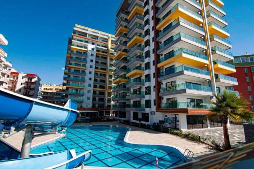 a swimming pool in front of a tall building at KURT SAFİR EURO 20 RESIDENCE NO:15 in Alanya
