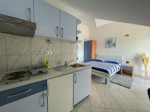 een keuken met een wastafel en een bed in een kamer bij Apartments Marija Magdalena in Hvar