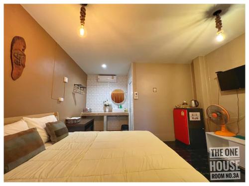 a bedroom with a large bed and a kitchen at The One House in Nan