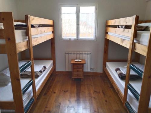 Reliegos的住宿－Las Hadas Albergue Peregrinos - Atención personalizada，带窗户的客房内的两张双层床
