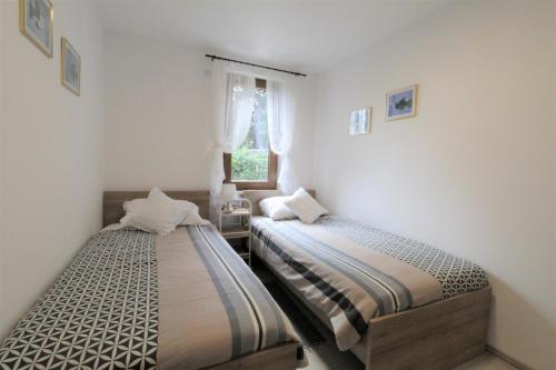 Dos camas en una habitación pequeña con ventana. en APP Mirjam - Savudrija, Umag, en Savudrija