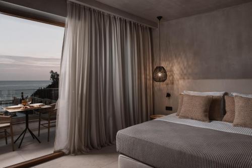 a bedroom with a bed and a view of the ocean at Myra Hotel in Kavala