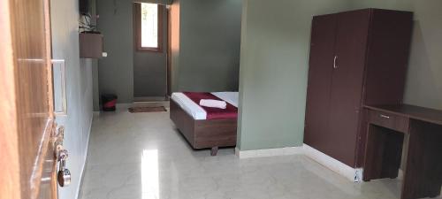 a small bedroom with a bed and a mirror at FAAZ Residency in Kozhikode