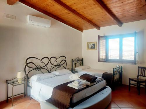 1 dormitorio con 2 camas y ventana en Parco Esmeralda - Family Residence e Breakfast en Marina di Camerota