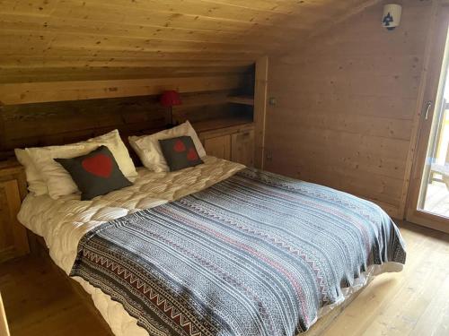 łóżko w pokoju z drewnianą ścianą w obiekcie Three bedroom Apartment, Samoens, Grand Massif w mieście Samoëns