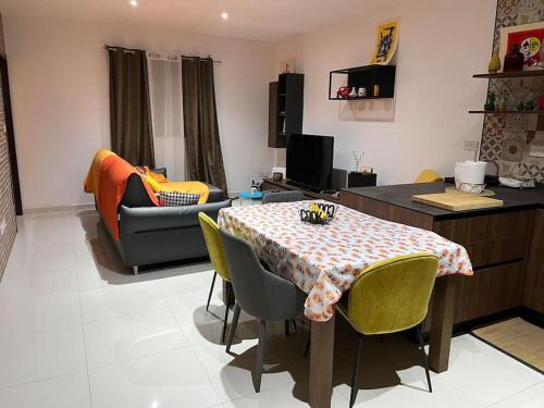 Duplex Maisonette with roof في Fgura: غرفة معيشة مع طاولة وأريكة